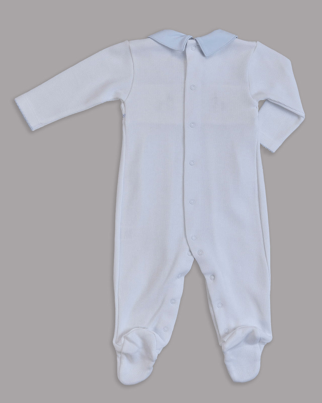 Enterizo blanco para bebé con detalles en celeste, ideal para combinar estilo y ternura.