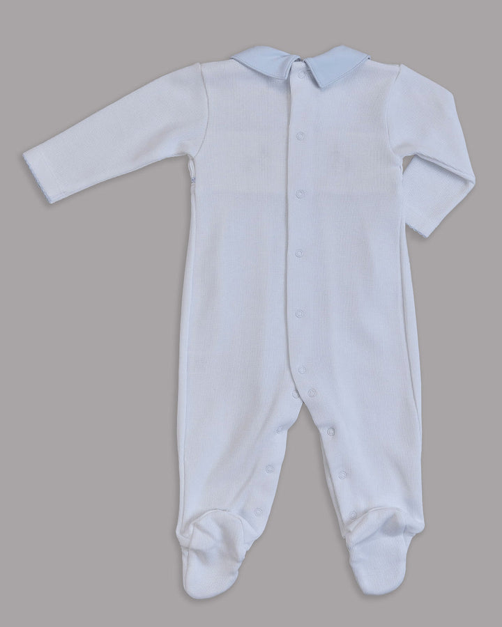 Enterizo blanco para bebé con detalles en celeste, ideal para combinar estilo y ternura.