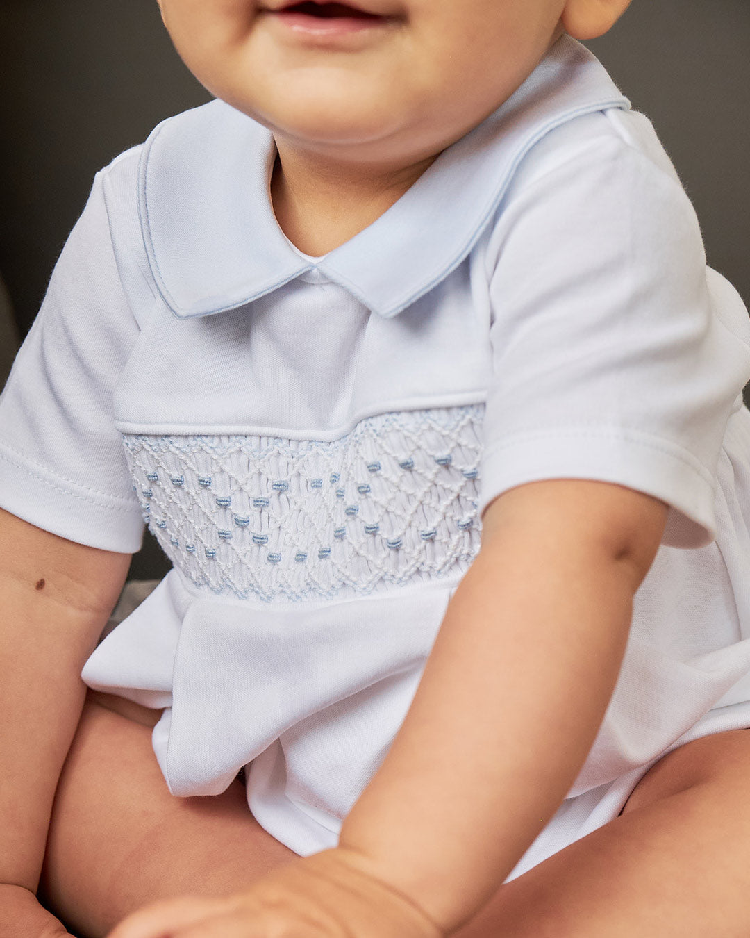 Bombacho de bebé en blanco con toques celestes, ideal para cualquier ocasión especial o casual.